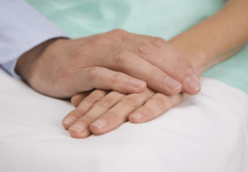 Hands clasping in palliative care