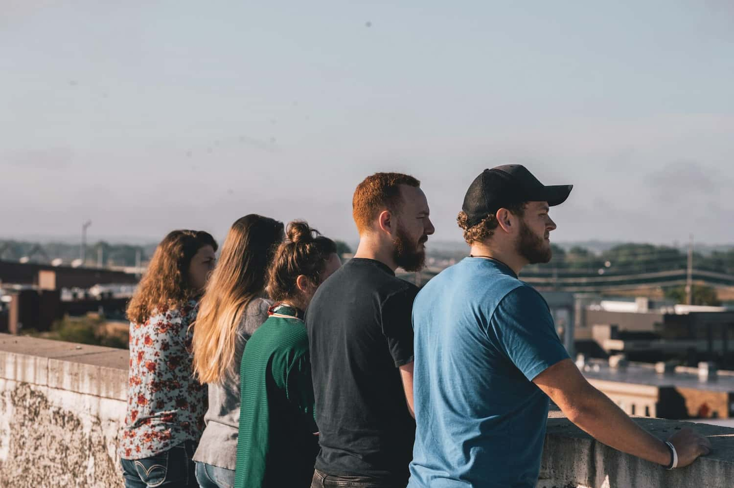 five young people standing on a rooftop