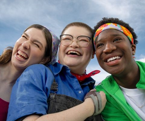 3 young people of diverse backgrounds smiling together