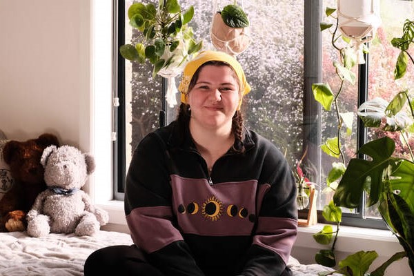 Young person impacted by cancer sitting on a bed. Donate through regular giving to cancer charity Canteen Australia