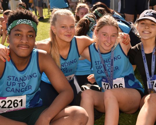 A group of young Canteen fundraisers at a running challenge event wearing Canteen bandannas and t shirts