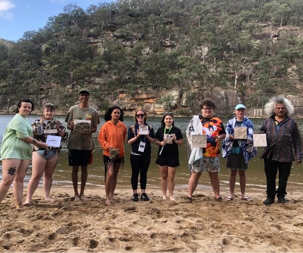 a group of people standing together on the shoreline