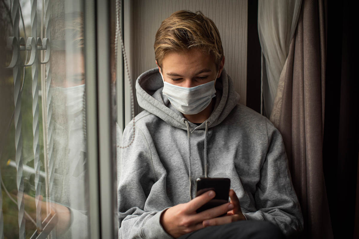 man wearing mask researching on phone