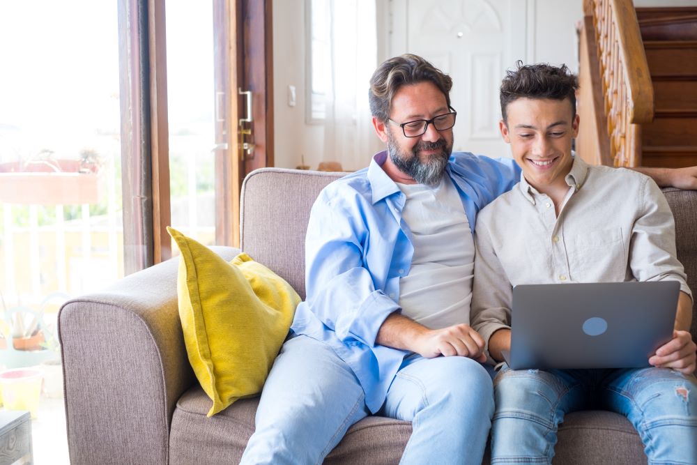 image of a father and son sitting together on a laptop