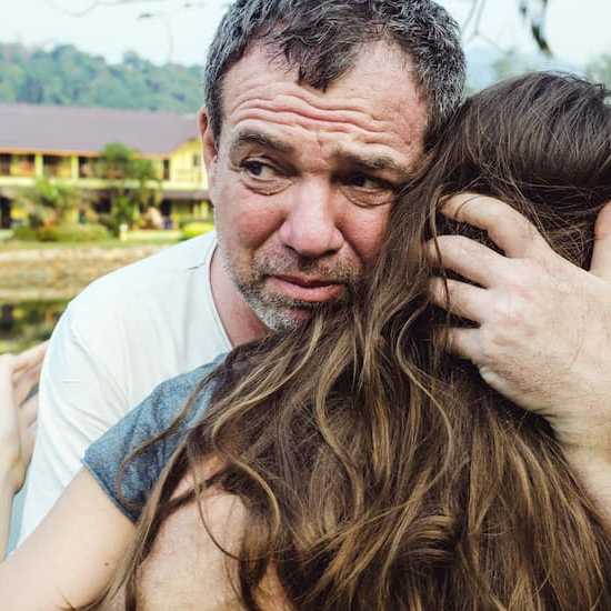 Upset father hugging daughter