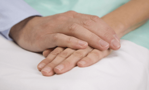 Hands clasping in palliative care