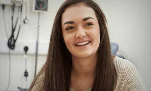 young girl smiling receiving support from youth cancer services