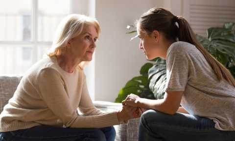 Young woman speaking with her mother about cancer