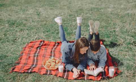 Siblings reading in a park