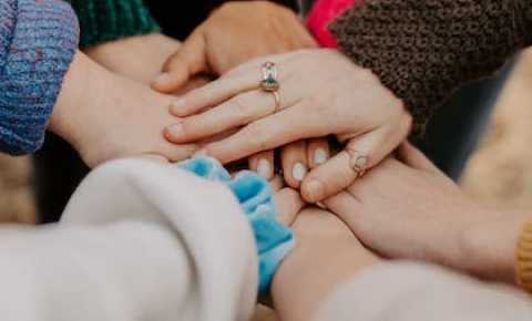 a group of hands joining together as a team