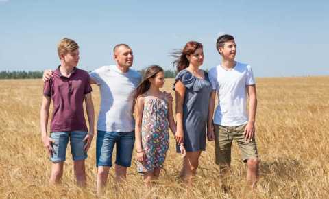 a family impacted by cancer standing together in a field