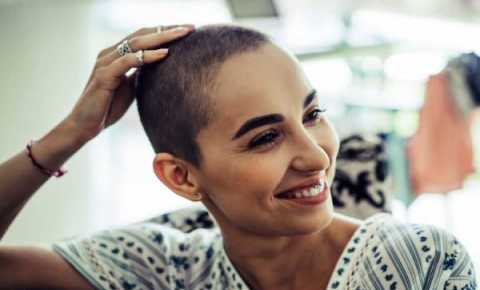 young person with cancer is looking to the side and smiling