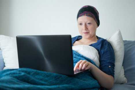 Young woman in hospital bed doing school work