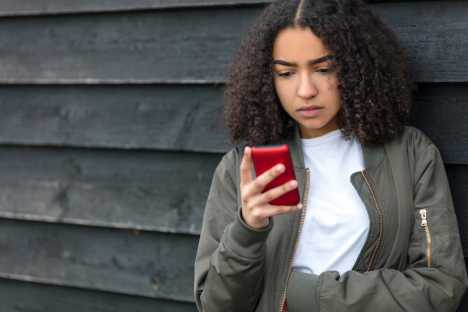 Girl looking for information about cancer on phone