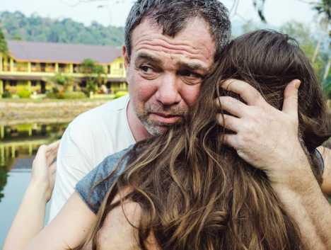 Upset father hugging daughter