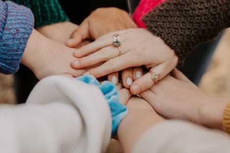 a group of hands joining together as a team