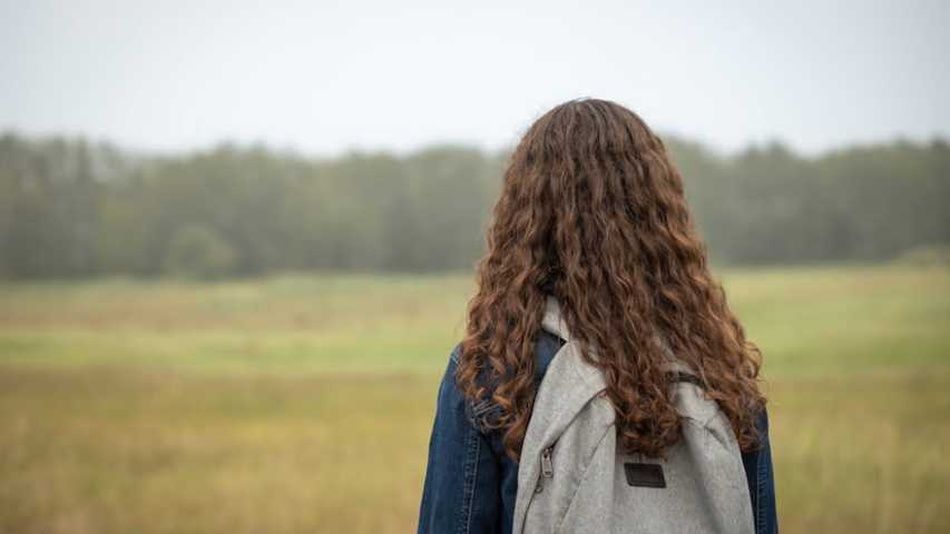 Girl with backpack looking into distance