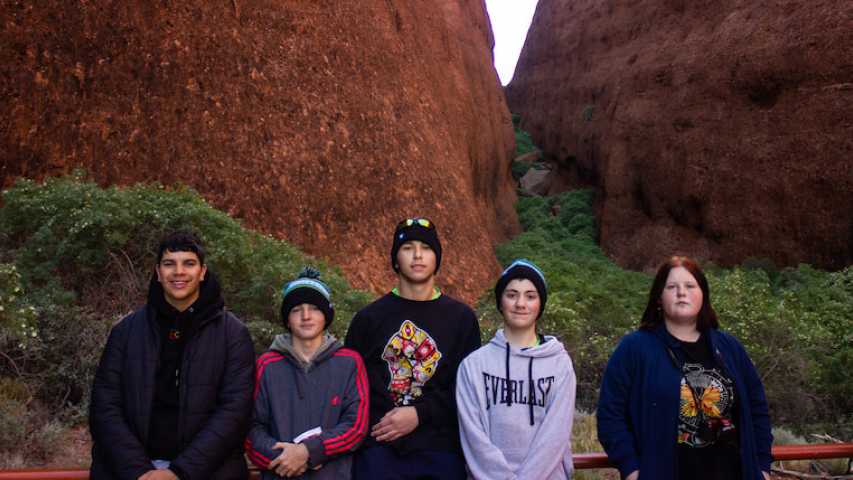group of young people from Canteen in front of two rock mountains