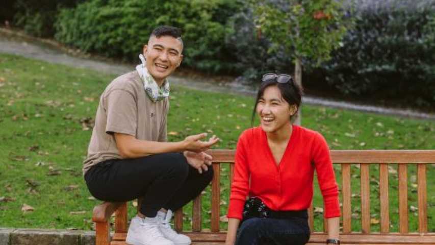 two young people sitting in a park