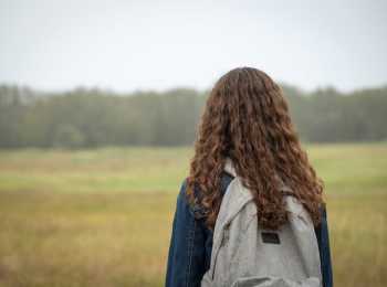 Girl with backpack looking into distance