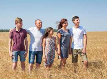 a family impacted by cancer standing together in a field