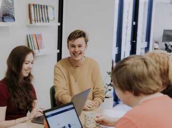 group of young people impacted by cancer smiling around a table